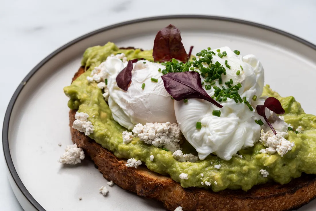 Smashed avocado on toast with poached eggs