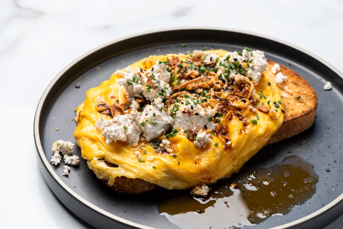 Eggs on toast with crumbled feta and herbs